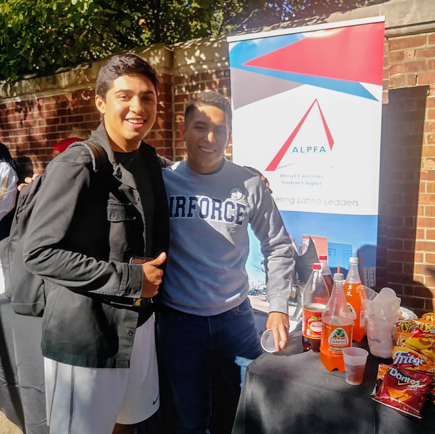 Two students pose in front ALPFA banner at Drexel event. 